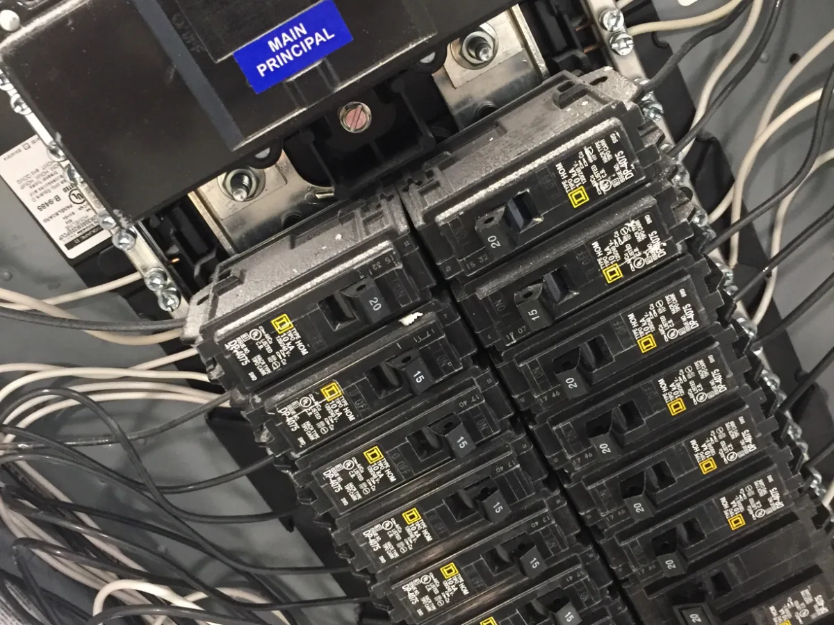 An open residential breaker panel with the main disconnect and branch circuits